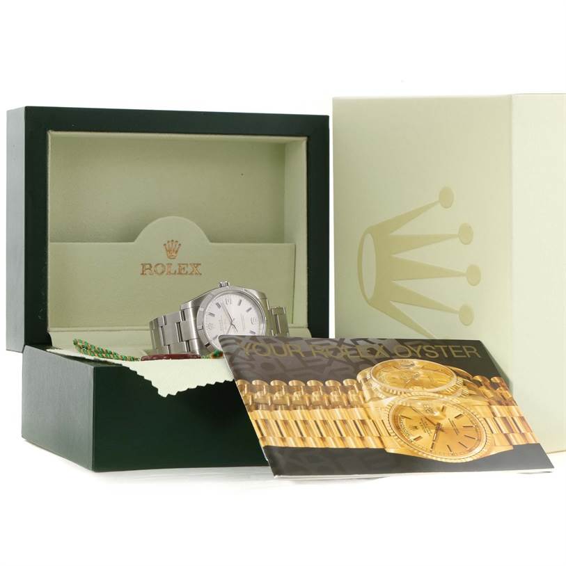 The Rolex Air-King 114210 Men's Stainless Steel Silver Dial 114210 Men's Stainless Steel Silver Dial watch is shown in its box with accompanying booklets and packaging materials.