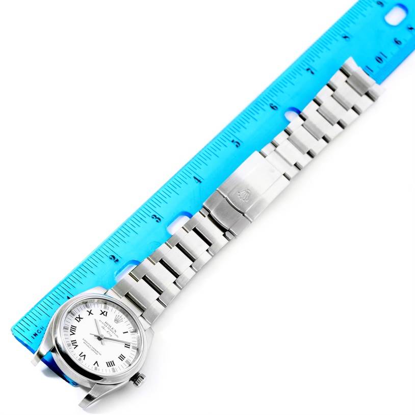 The image shows a Rolex Air-King 114200 Stainless Steel White Dial 114200 Stainless Steel White Dial watch laid flat next to a blue ruler, displaying the watch face and metal band.