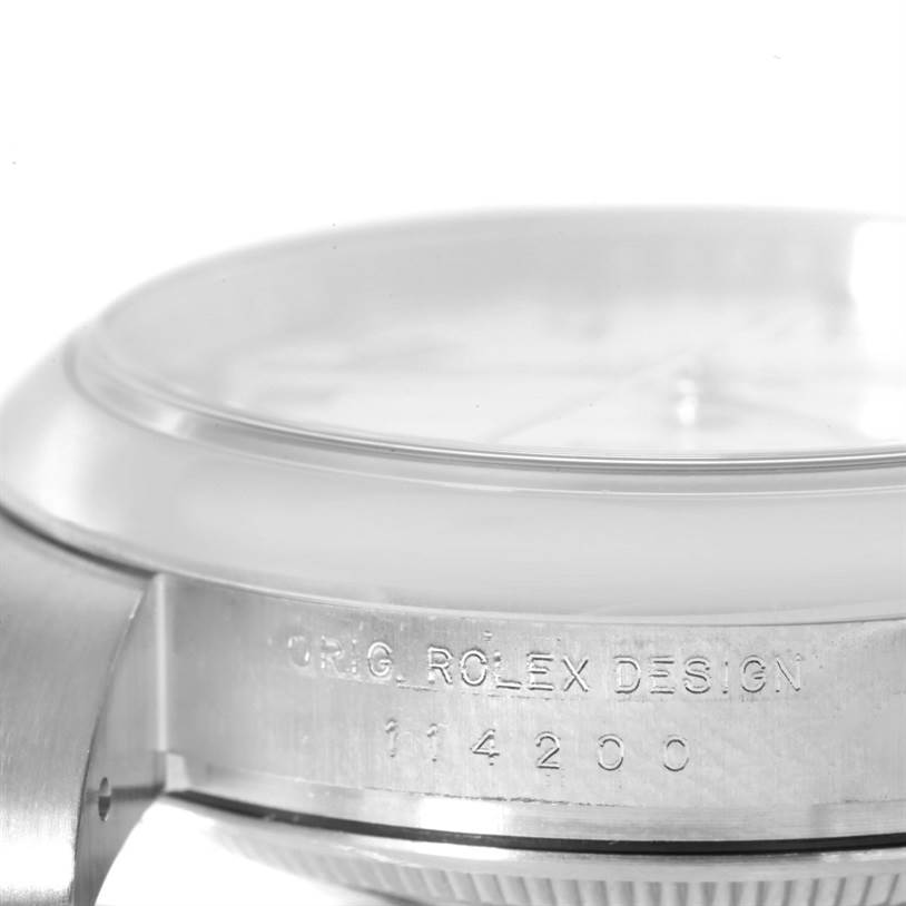 This is a close-up side view of the Rolex Air-King 114200 Stainless Steel White Dial 114200 Stainless Steel White Dial model, showcasing part of the case and the engraved design details.