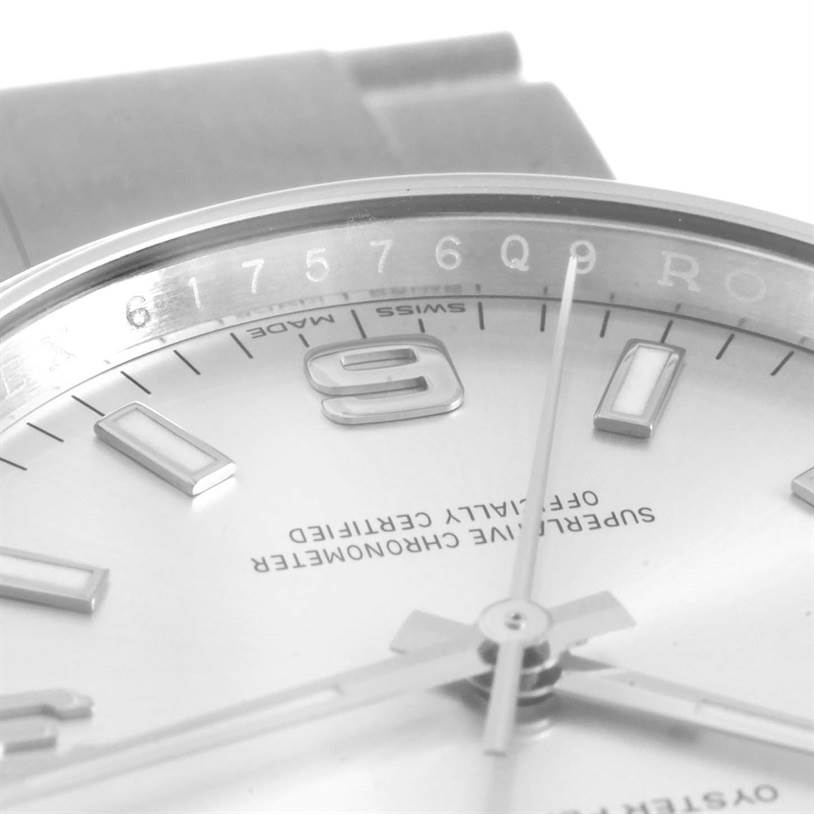 This close-up image of the Rolex Air-King 114200 Men's Stainless Steel Silver Dial 114200 Men's Stainless Steel Silver Dial watch shows part of the dial, hands, and a portion of the bezel.