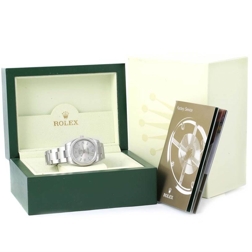 The Rolex Air-King 114234 Men's Stainless Steel Silver Dial 114234 Men's Stainless Steel Silver Dial watch is displayed front-on inside its green box, with manuals to the right.