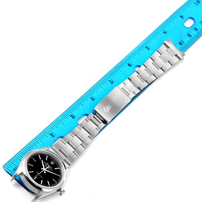 The image shows a Rolex Air-King 14000 Men's Stainless Steel Black Dial 14000 Men's Stainless Steel Black Dial watch from above, displaying its black dial, stainless steel case, and bracelet against a blue ruler backdrop.