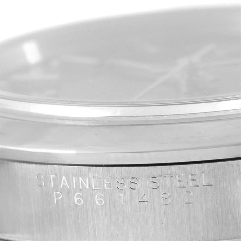 The image shows a close-up of the side of a Rolex Air-King 14000 Men's Stainless Steel Black Dial 14000 Men's Stainless Steel Black Dial watch case with "STAINLESS STEEL" and the serial number engraved.