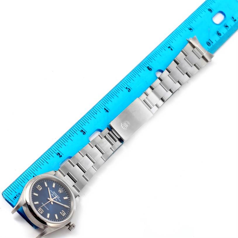 The image shows a Rolex Air-King 14000 Men's Stainless Steel Blue Dial 14000 Men's Stainless Steel Blue Dial watch laid flat with its band extended next to a blue ruler.