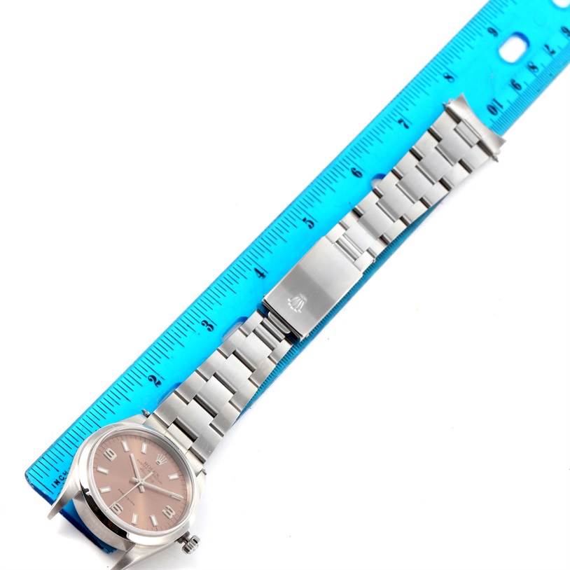 This image shows a Rolex Air-King 14000 Men's Stainless Steel Pink Dial 14000 Men's Stainless Steel Pink Dial watch laid flat with its bracelet extended alongside a ruler.