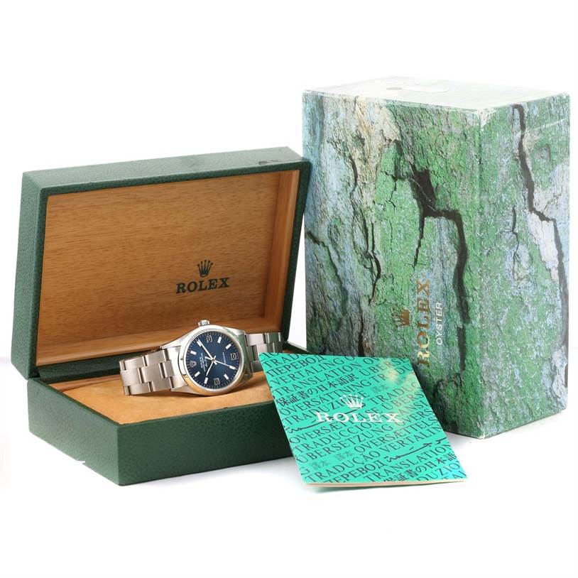 The Rolex Air-King 14000 Men's Stainless Steel Blue Dial 14000 Men's Stainless Steel Blue Dial watch is shown inside its open green box, with packaging and a booklet beside it.