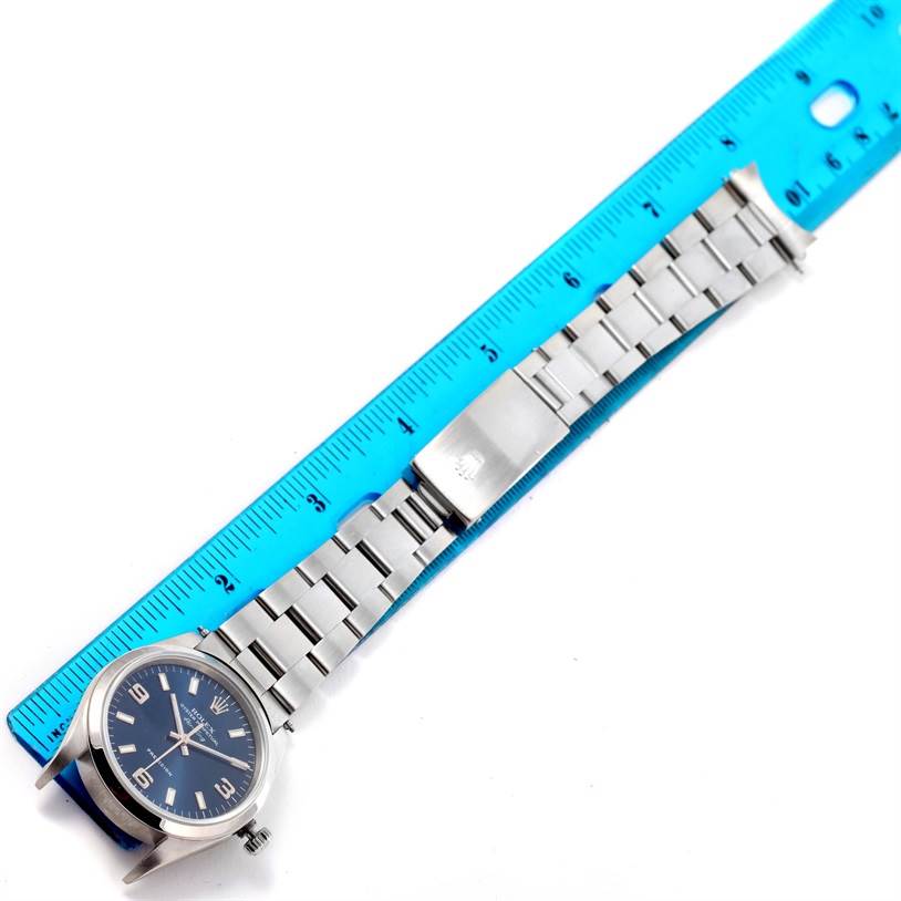 The image shows a side view of a Rolex Air-King 14000 Men's Stainless Steel Blue Dial 14000 Men's Stainless Steel Blue Dial watch with its bracelet, placed next to a blue ruler for measurement.