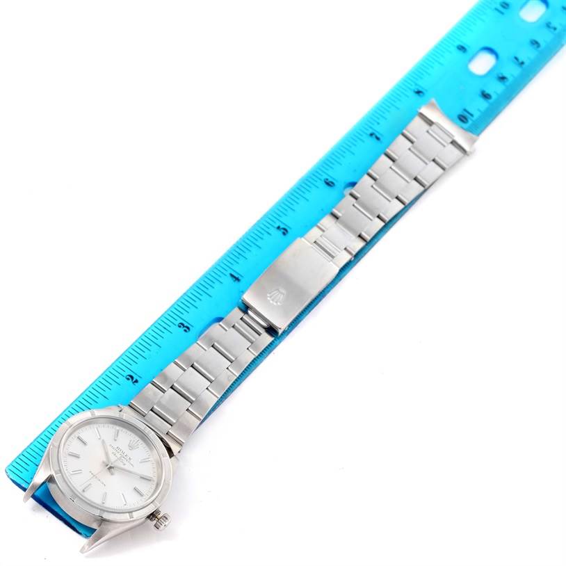 The image shows a side view of a Rolex Air-King 14010 Men's Stainless Steel Silver Dial 14010 Men's Stainless Steel Silver Dial watch with its metal bracelet fully extended next to a blue ruler.