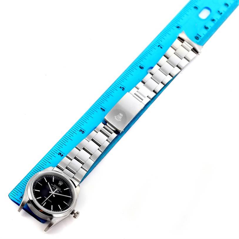 This image shows a top-down view of a Rolex Air-King 14000 Men's Stainless Steel Black Dial 14000 Men's Stainless Steel Black Dial watch, highlighting the dial, bracelet, and clasp next to a blue ruler for scale.