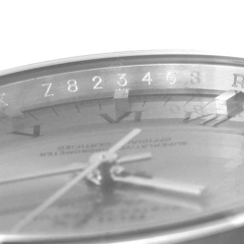 The image shows a close-up of the dial and bezel of the Rolex Air-King 114200 Men's Stainless Steel Grey Dial 114200 Men's Stainless Steel Grey Dial watch, highlighting the serial numbers.