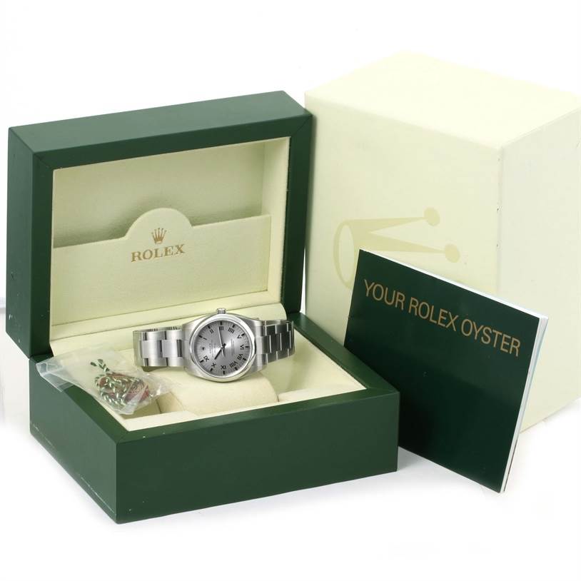 The image shows a Rolex Air-King 114200 Men's Stainless Steel Grey Dial 114200 Men's Stainless Steel Grey Dial watch positioned in its open green box, accompanied by a booklet and accessory.