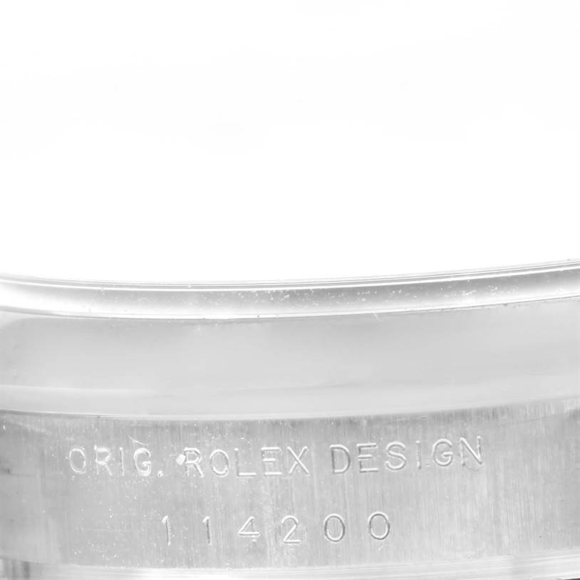 The image shows a close-up of the case of a Rolex Air-King 114200 Men's Stainless Steel Grey Dial 114200 Men's Stainless Steel Grey Dial watch, displaying the engraved model number and "Orig. Rolex Design."