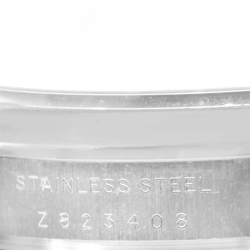 This image shows a close-up of the Rolex Air-King 114200 Men's Stainless Steel Grey Dial 114200 Men's Stainless Steel Grey Dial model's stainless steel casing with a visible serial number.