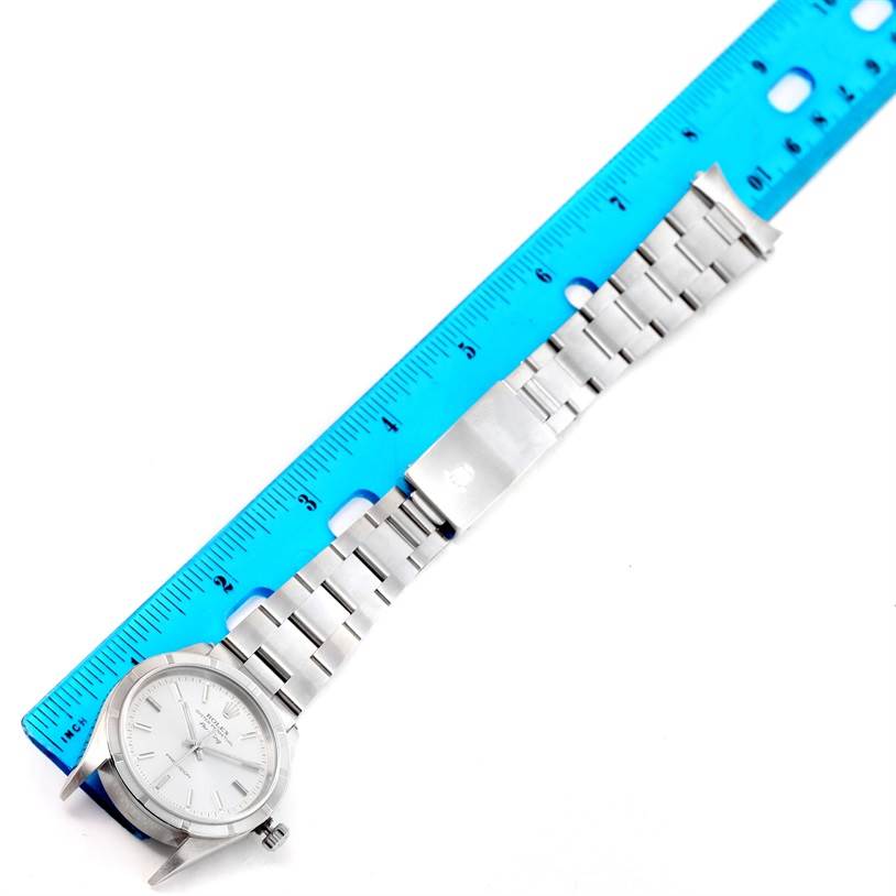 The Rolex Air-King 14010 Men's Stainless Steel Silver Dial 14010 Men's Stainless Steel Silver Dial watch is laid flat with its face, stainless steel bracelet, and clasp visible, alongside a blue ruler for scale.