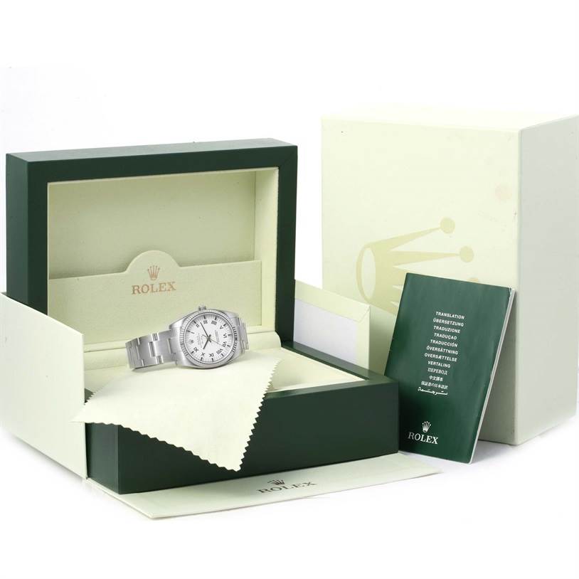 The Rolex Air-King 114234 Men's Stainless Steel White Dial 114234 Men's Stainless Steel White Dial watch is shown at a slight angle inside its box with documentation and a cleaning cloth.