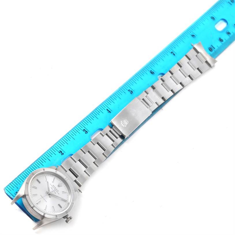 The image shows a Rolex Air-King 14010 Men's Stainless Steel Silver Dial 14010 Men's Stainless Steel Silver Dial watch laid flat on a blue ruler, displaying the watch face, stainless steel bracelet, and clasp.