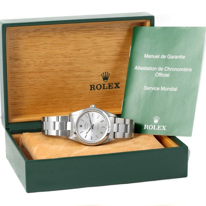 The Rolex Air-King 14000 Men's Stainless Steel Silver Dial 14000 Men's Stainless Steel Silver Dial watch is displayed in an open green and wood box with a warranty booklet on the side.