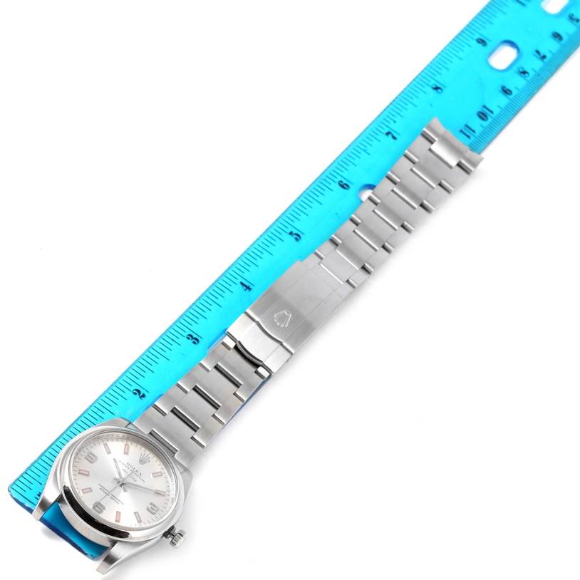 The image shows a Rolex Air-King 114200 Men's Stainless Steel Silver Dial 114200 Men's Stainless Steel Silver Dial watch laid flat next to a blue ruler, displaying the face, bracelet, and clasp.