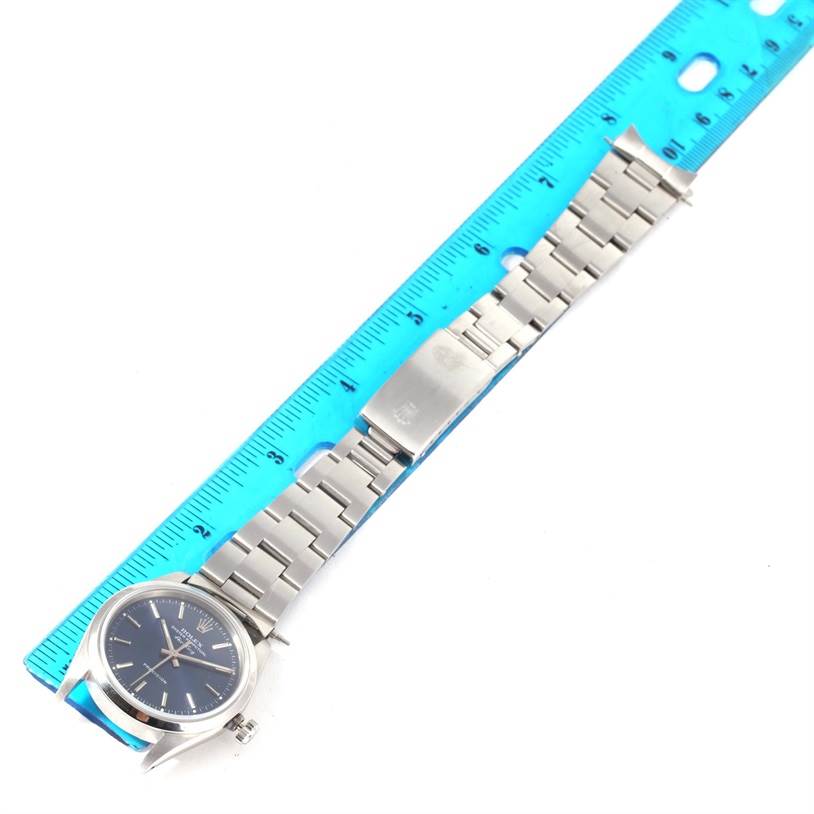 This image shows the Rolex Air-King 14000 Men's Stainless Steel Blue Dial 14000 Men's Stainless Steel Blue Dial watch laid flat beside a blue ruler, displaying the face, bezel, band, and clasp.