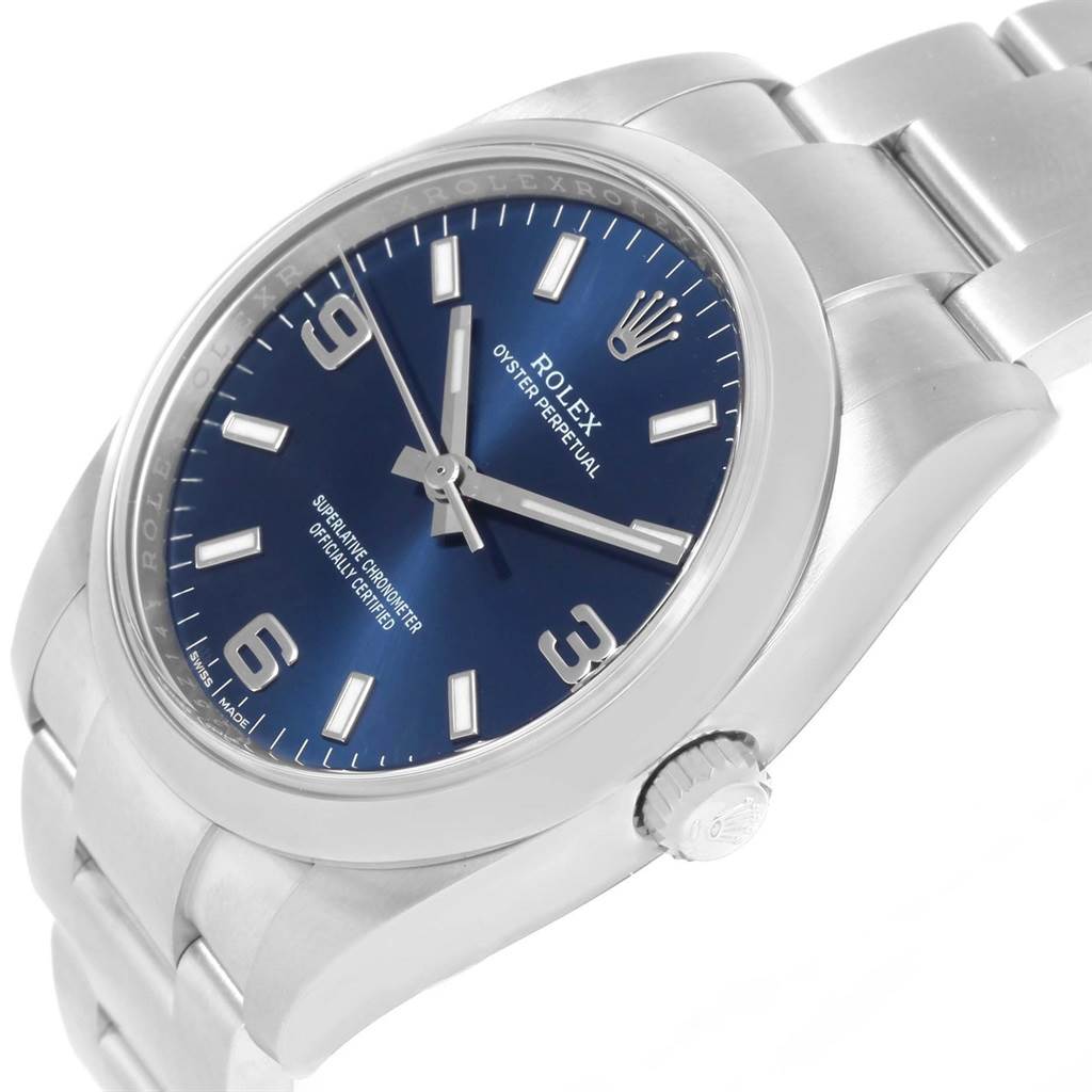 The Rolex Air-King 114200BLASO Men's Stainless Steel Blue Dial 114200BLASO Men's Stainless Steel Blue Dial watch is shown from a three-quarter angle, highlighting its face, crown, and part of the bracelet.