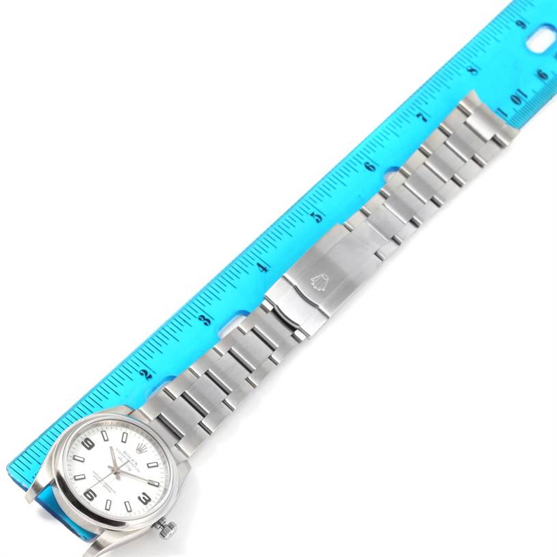 The image shows a Rolex Air-King 114200 Men's Stainless Steel White Dial 114200 Men's Stainless Steel White Dial watch laid flat with its face and bracelet visible, alongside a blue ruler for scale.