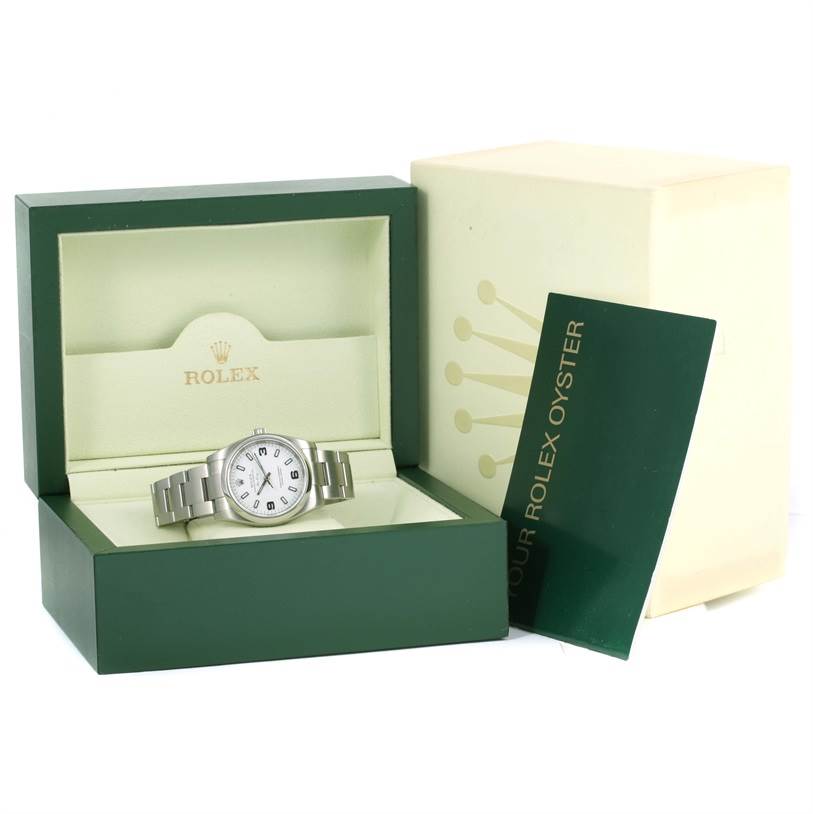 The Rolex Air-King 114200 Men's Stainless Steel White Dial 114200 Men's Stainless Steel White Dial watch is displayed in its open box with the outer packaging and a booklet beside it.