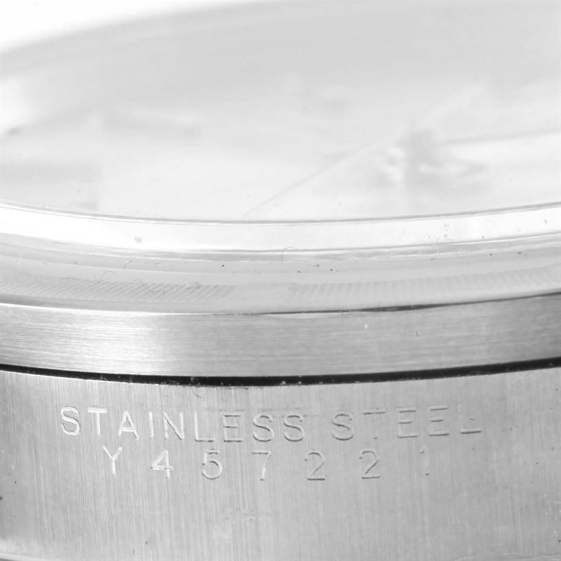 The image shows a close-up of the side view of a Rolex Air-King 14010 Men's Stainless Steel Silver Dial 14010 Men's Stainless Steel Silver Dial watch, focusing on the stainless steel casing with an engraved serial number.