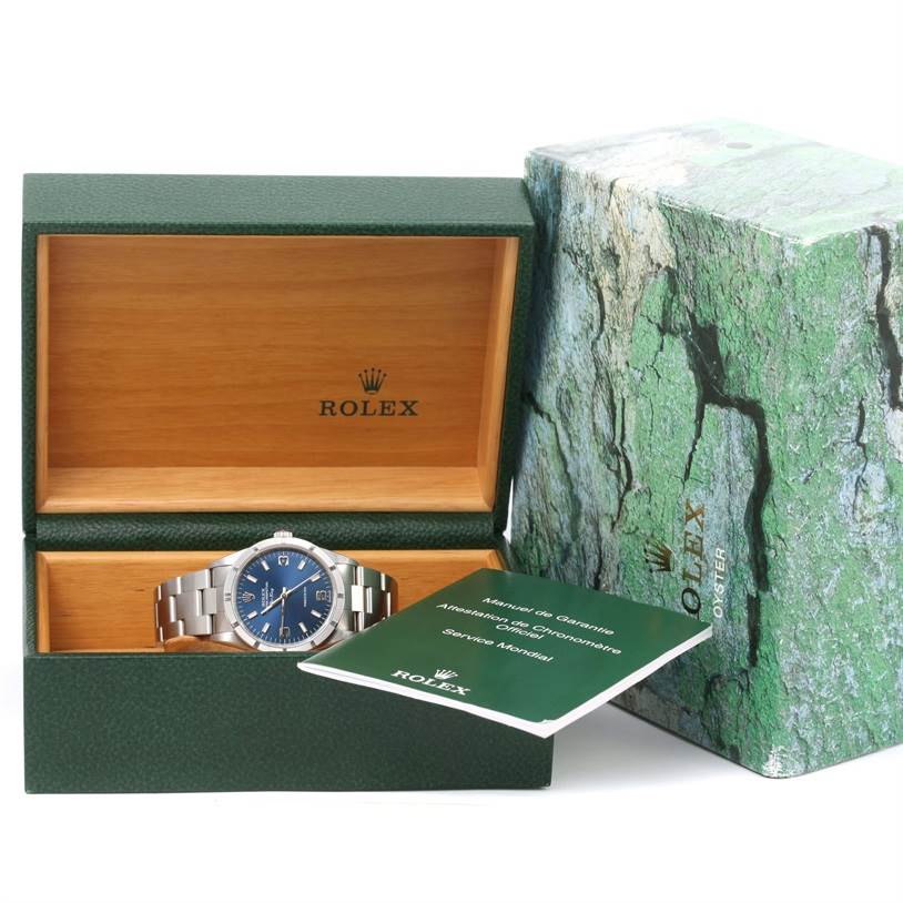 The Rolex Air-King 14010 Men's Stainless Steel Blue Dial 14010 Men's Stainless Steel Blue Dial watch is displayed front-facing inside its open green box, accompanied by the warranty booklet.