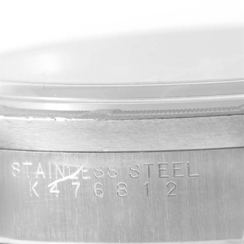 This close-up image shows the side of the Rolex Air-King 14010 Men's Stainless Steel Blue Dial 14010 Men's Stainless Steel Blue Dial watch case, featuring part of the bezel and the engraving "STAINLESS STEEL" with a serial number.