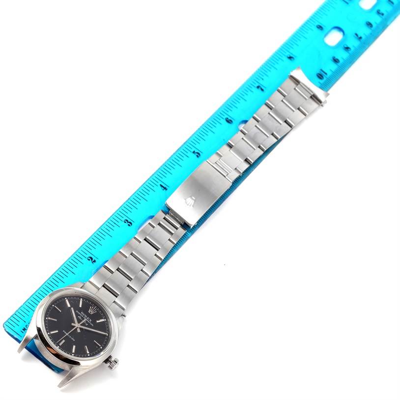 The image shows a Rolex Air-King 14000 Men's Stainless Steel Black Dial 14000 Men's Stainless Steel Black Dial watch laid flat with its band stretched out, placed alongside a blue ruler.
