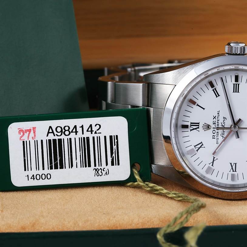 The image shows a partial view of an Air-King Rolex watch, highlighting the dial and a barcode tag.