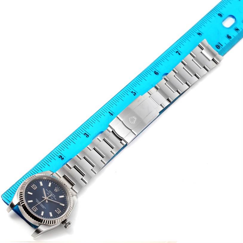The image shows a Rolex Air-King 114234 Men's Stainless Steel Blue Dial 114234 Men's Stainless Steel Blue Dial watch laid flat next to a ruler, displaying the face, bracelet, and clasp from a top-down angle.