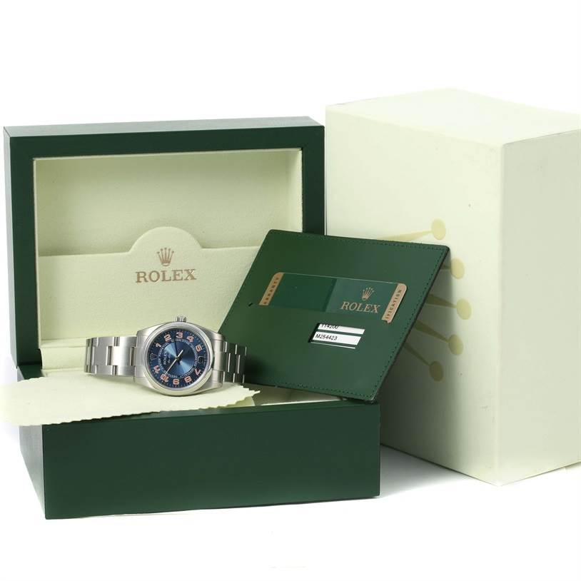 The image shows a Rolex Air-King 114200 Men's Stainless Steel Blue Dial 114200 Men's Stainless Steel Blue Dial watch displayed in its box, along with the warranty card and green cardholder.