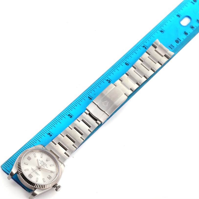 The image shows a top view of the Rolex Air-King 114234 Men's Stainless Steel Silver Dial 114234 Men's Stainless Steel Silver Dial watch, highlighting the face, crown, bracelet, and clasp next to a ruler for measurement.