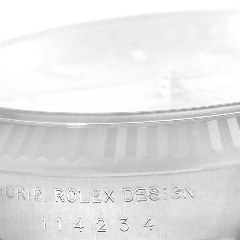 This close-up image of the Rolex Air-King 114234 Men's Stainless Steel Silver Dial 114234 Men's Stainless Steel Silver Dial watch shows the bezel and part of the case, highlighting the "ORIG. ROLEX DESIGN 114234" inscription.