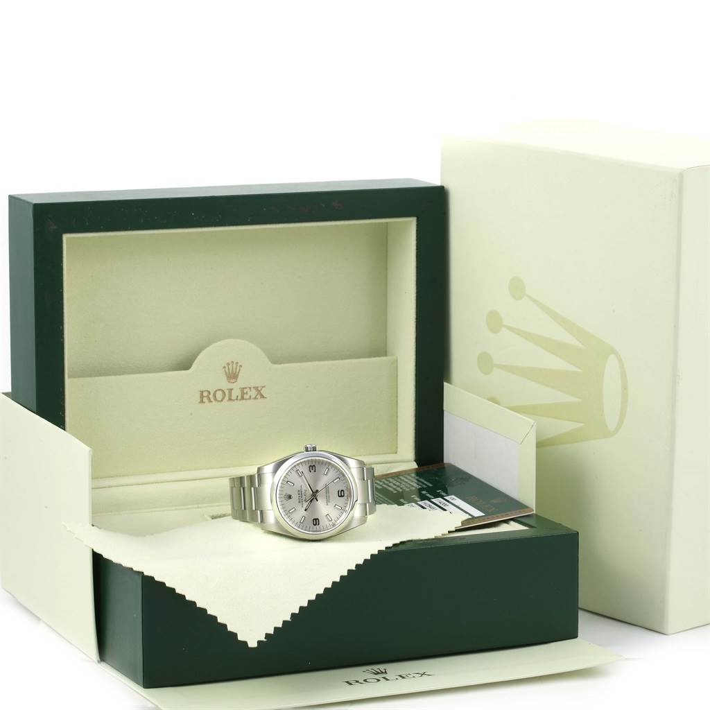 The image shows a Rolex Air-King 114200 Men's Stainless Steel Silver Dial 114200 Men's Stainless Steel Silver Dial watch with its stainless steel bracelet, placed inside its green and beige display box.
