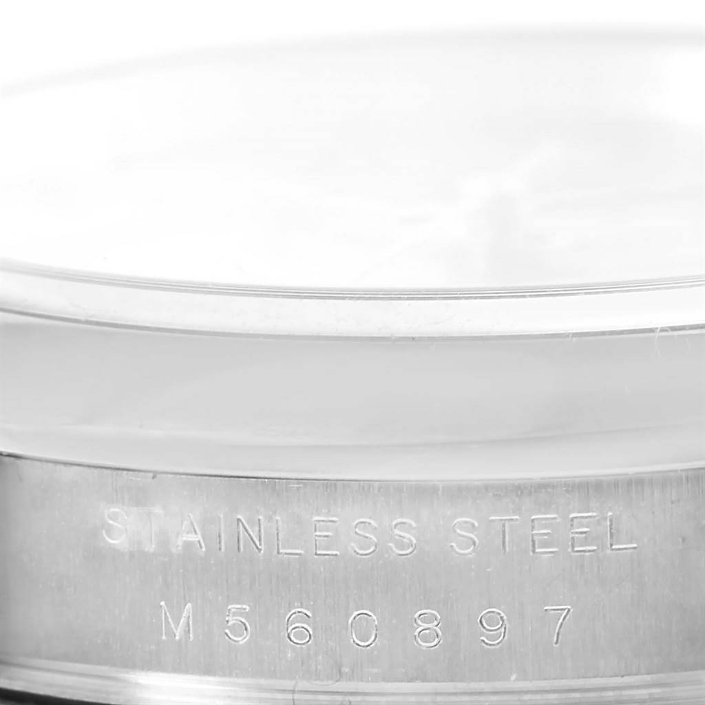This image shows a close-up of the side of a Rolex Air-King 114200 Men's Stainless Steel Grey Dial 114200 Men's Stainless Steel Grey Dial watch, focusing on its stainless steel casing and serial number.
