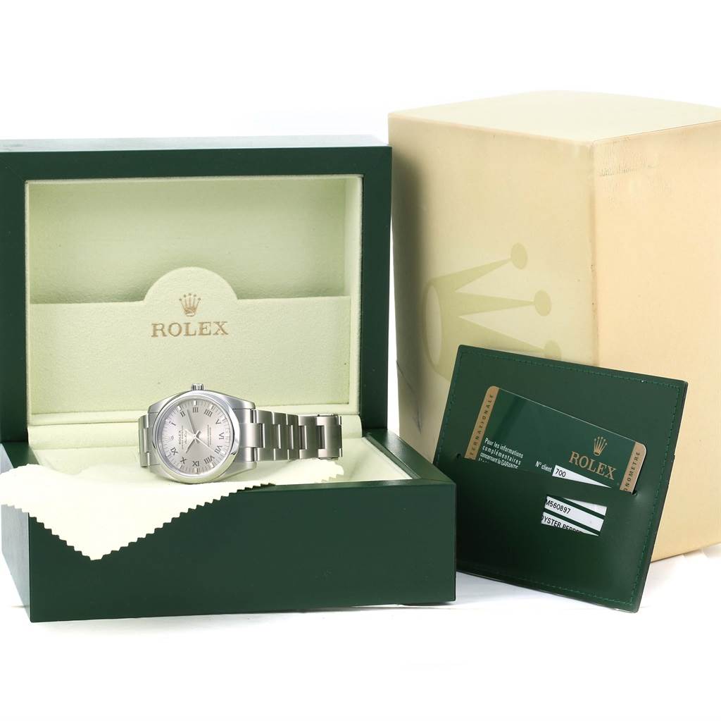 The image shows a Rolex Air-King 114200 Men's Stainless Steel Grey Dial 114200 Men's Stainless Steel Grey Dial watch in its open box with a cleaning cloth and a warranty card holder beside it.