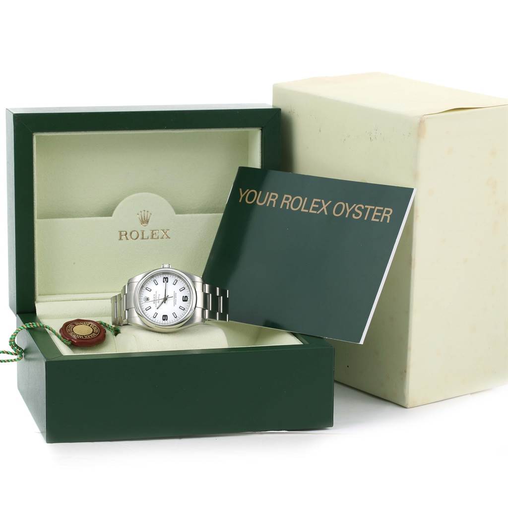 The image shows a Rolex Air-King 114200 Men's Stainless Steel White Dial 114200 Men's Stainless Steel White Dial watch in its open box with a manual, tag, and outer packaging in the background.