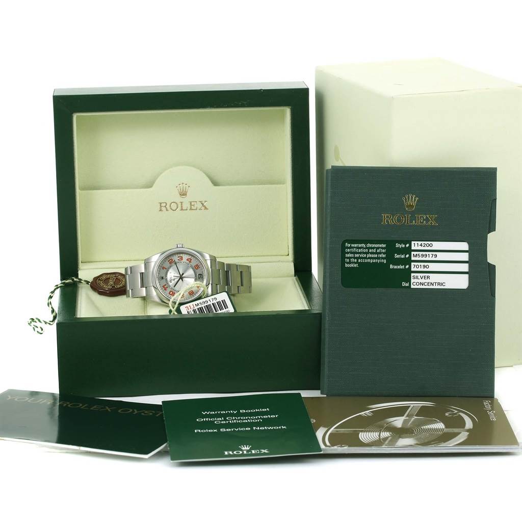 The image shows a Rolex Air-King 114200 Men's Stainless Steel Silver Dial 114200 Men's Stainless Steel Silver Dial watch in an open box, with warranty booklets and accessories displayed around it.