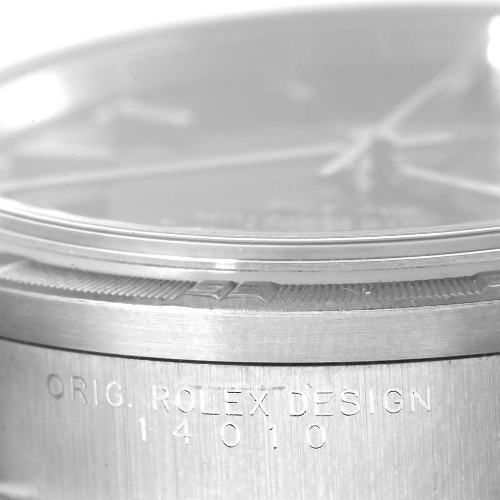 The image shows a close-up side view of a Rolex Air-King 14010 Men's Stainless Steel Blue Dial 14010 Men's Stainless Steel Blue Dial watch bezel, crystal, and partially visible case with engravings.