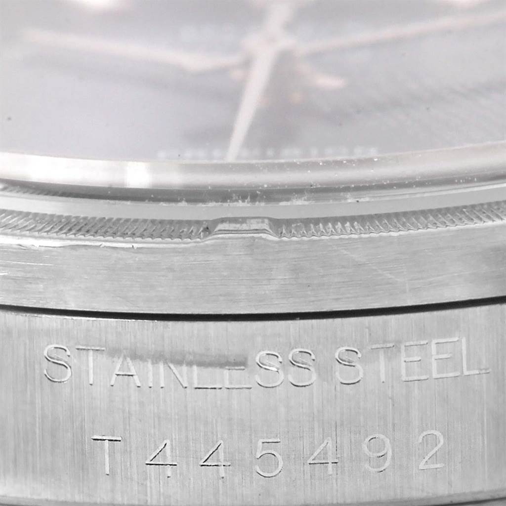 Close-up of the side view of a Rolex Air-King 14010 Men's Stainless Steel Blue Dial 14010 Men's Stainless Steel Blue Dial watch showing part of the crystal and engraved stainless steel case with serial number.