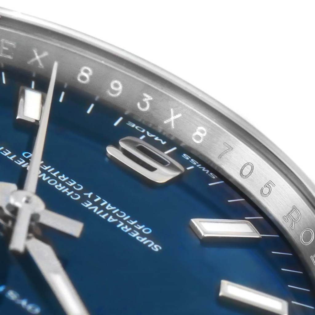The close-up angle of the Rolex Air-King 114200 Men's Stainless Steel Blue Dial 114200 Men's Stainless Steel Blue Dial watch shows the bezel with engraved numerals, part of the dial, and the hour markers.