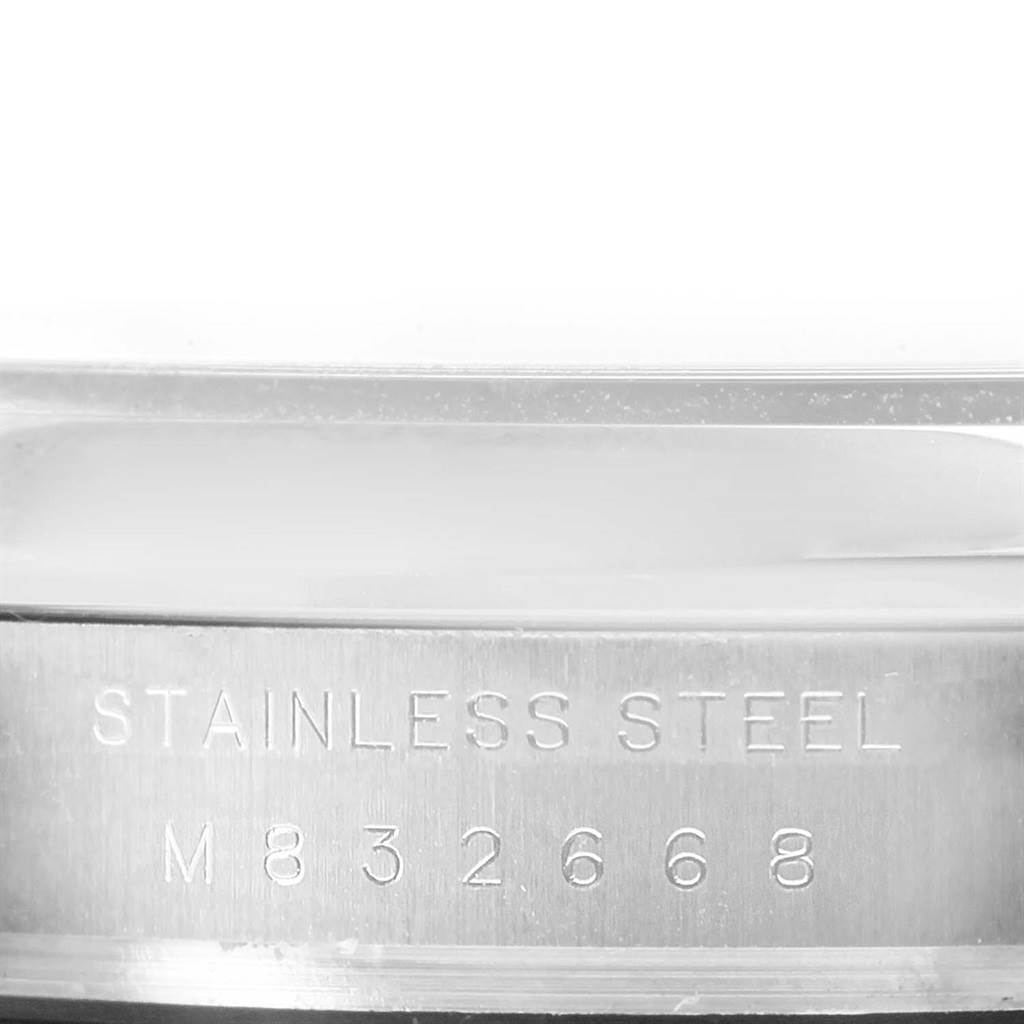 The image shows a close-up of the stainless steel case of a Rolex Air-King 114200 Men's Stainless Steel Blue Dial 114200 Men's Stainless Steel Blue Dial watch, with an engraved model number.