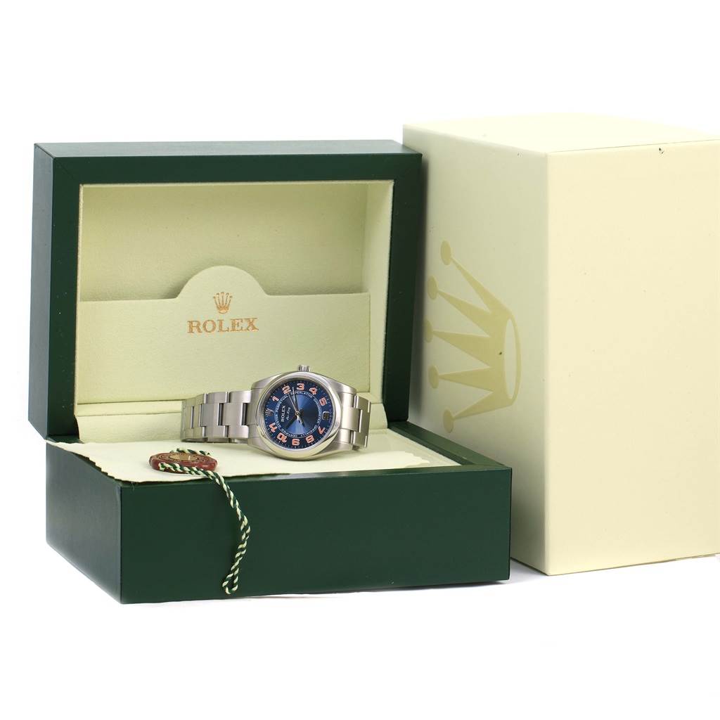 The image shows a Rolex Air-King 114200 Men's Stainless Steel Blue Dial 114200 Men's Stainless Steel Blue Dial watch displayed in an open green and beige Rolex box, with its face and bracelet visible.