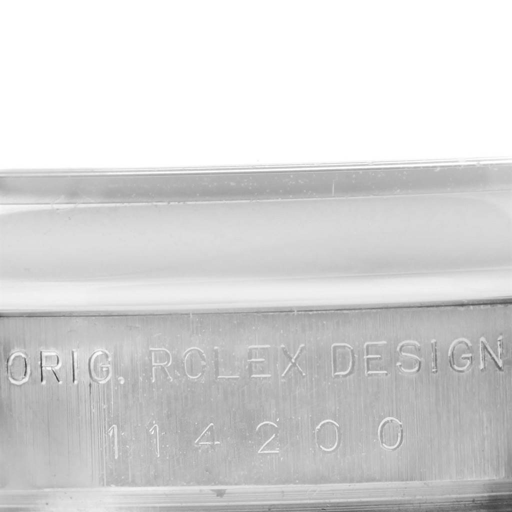 The image shows a close-up of the engraved serial number and "ORIG. ROLEX DESIGN" on the Air-King model by Rolex.