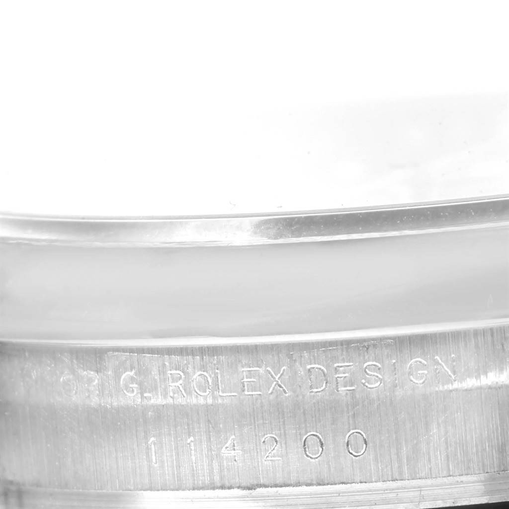 The image shows a close-up of the engraved serial number and "Rolex Design" text on the side of a Rolex Air-King 114200 Men's Stainless Steel Silver Dial 114200 Men's Stainless Steel Silver Dial watch case.