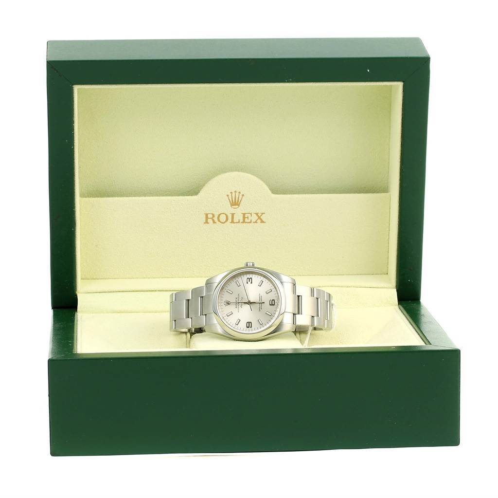 The Rolex Air-King 114200 Men's Stainless Steel Silver Dial 114200 Men's Stainless Steel Silver Dial watch is displayed frontally in an open green and beige Rolex box.