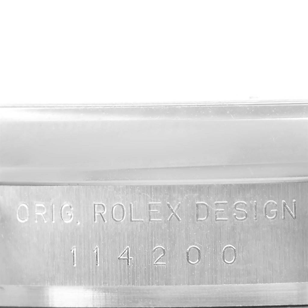 This close-up image of an Air-King by Rolex shows the watch's case with "ORIG. ROLEX DESIGN 114200" engraved on it.