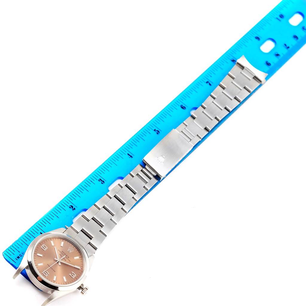 The Rolex Air-King 14000 Men's Stainless Steel Pink Dial 14000 Men's Stainless Steel Pink Dial watch is shown laying flat with its bracelet measured against a blue ruler.